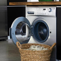 front-loading washing machine with door open and a wicker basket with clothes in it 